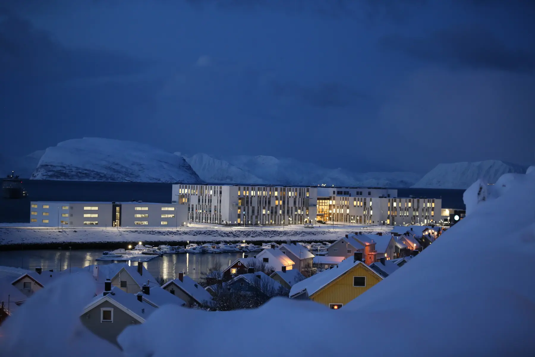 Bilde av det nye sykehuset for Vest-Finnmark, med bebyggelse i forgrunnen.