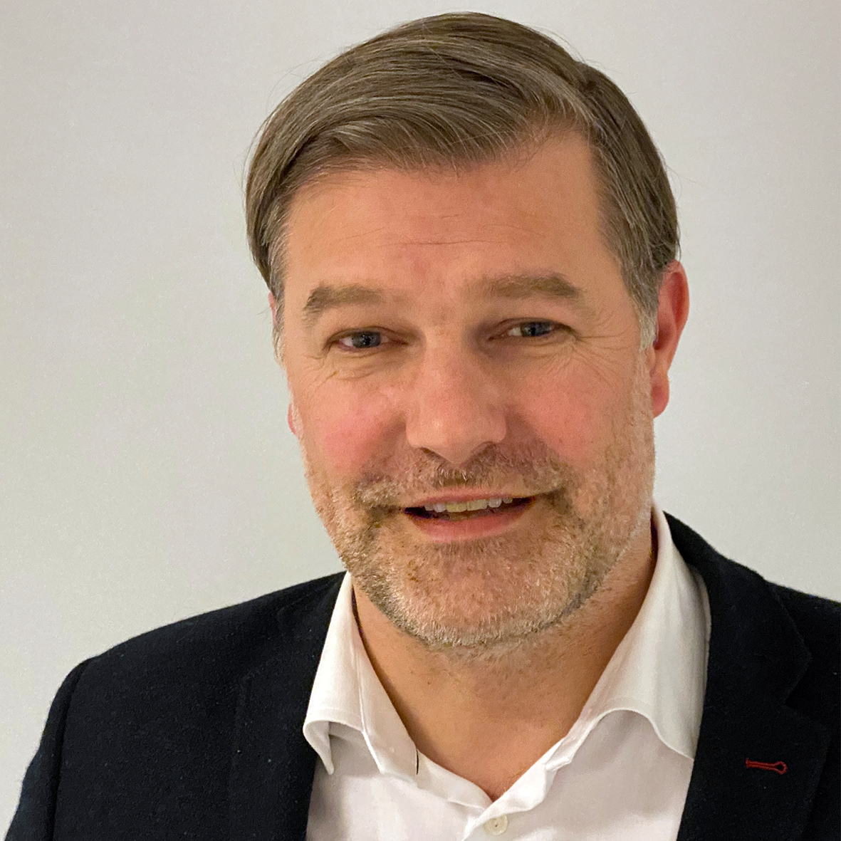 En mann som smiler til kameraet