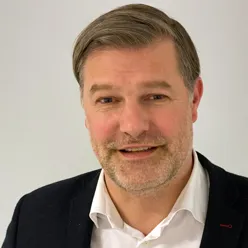 En mann som smiler til kameraet