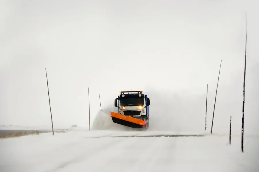 En lastebil som kjører gjennom snøen
