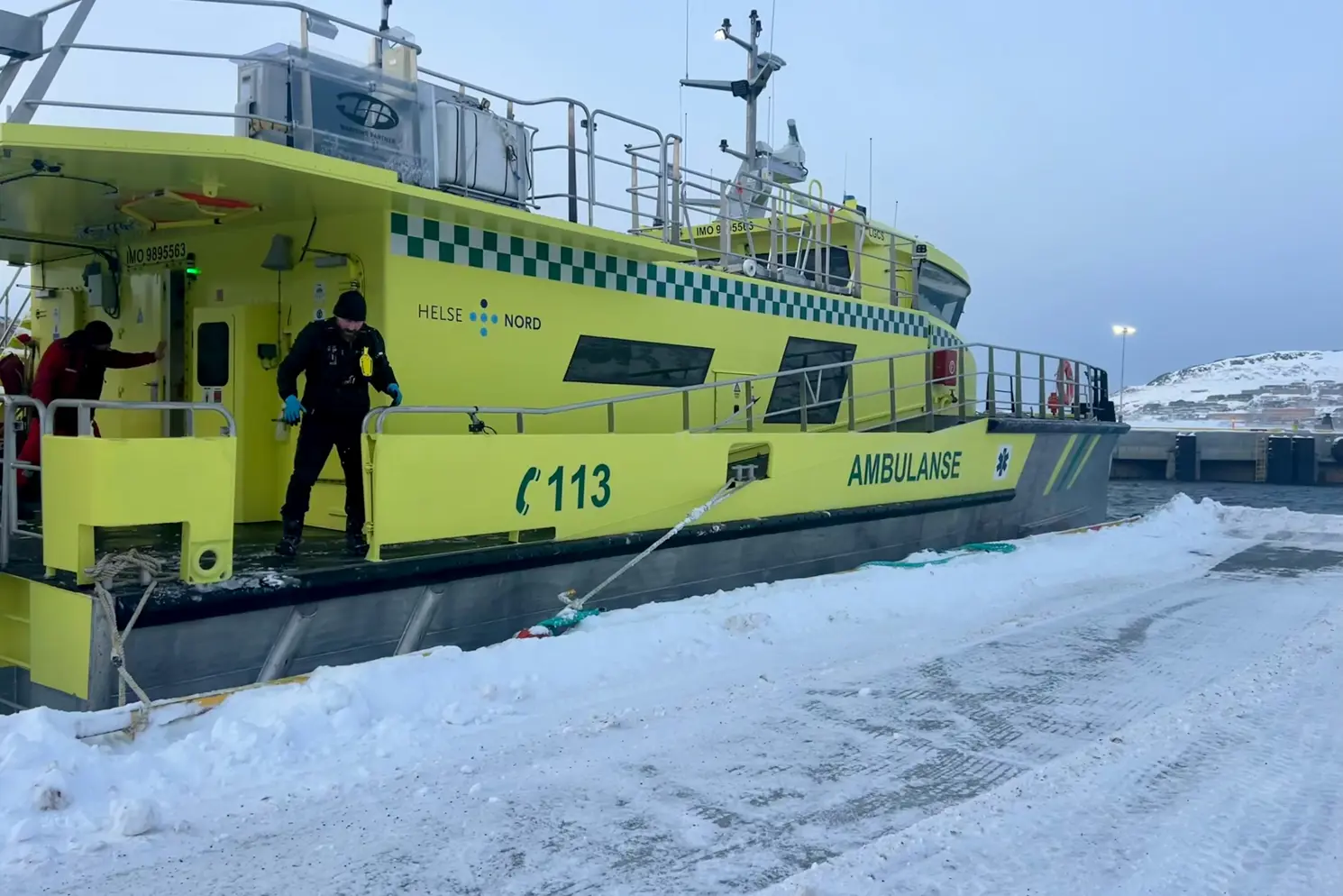 En person som står på en gul båt i snøen