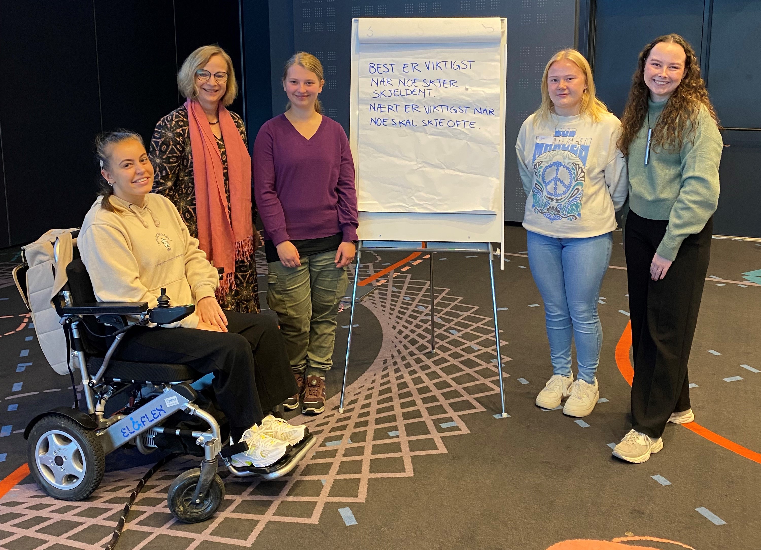 En gruppe kvinner som står ved siden av en person i rullestol