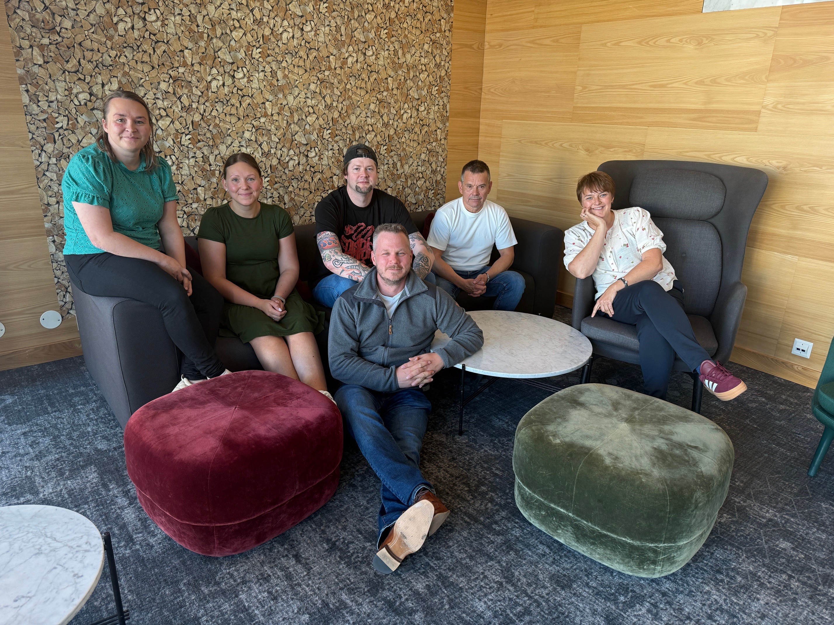 En gruppe mennesker som sitter i en sofa