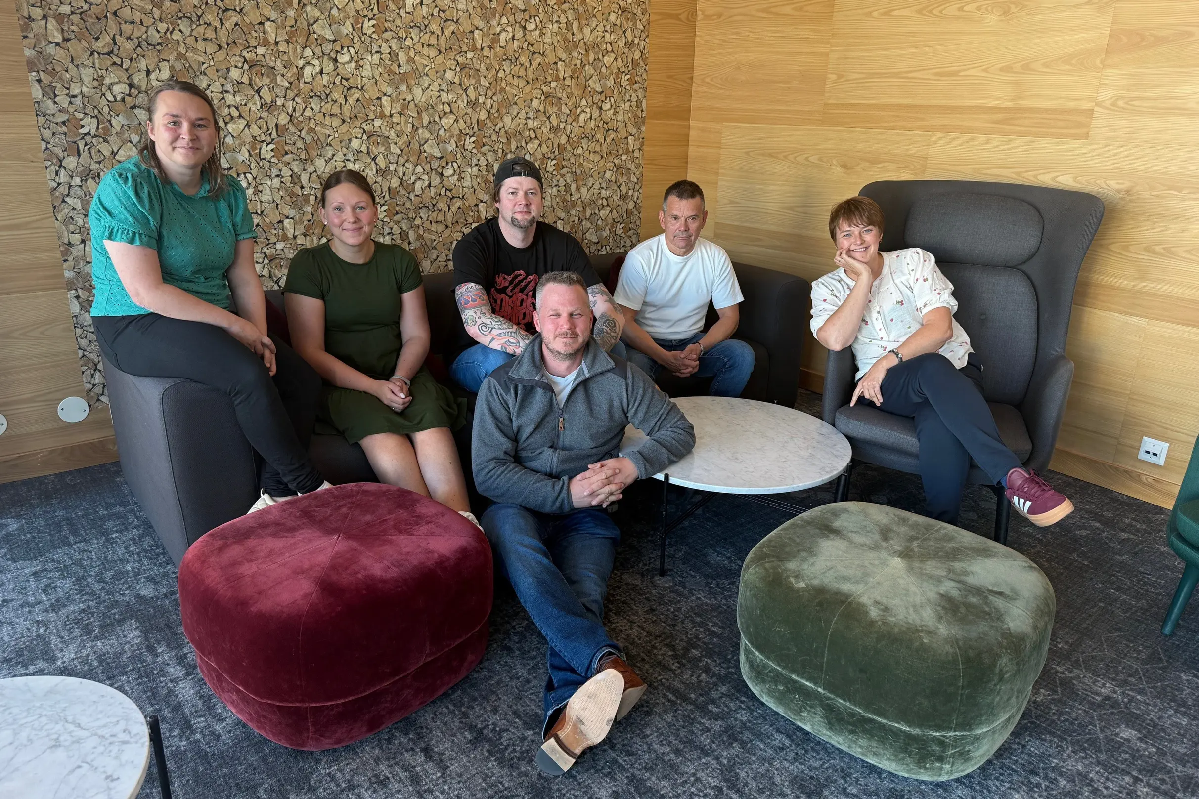 En gruppe mennesker som sitter i en sofa