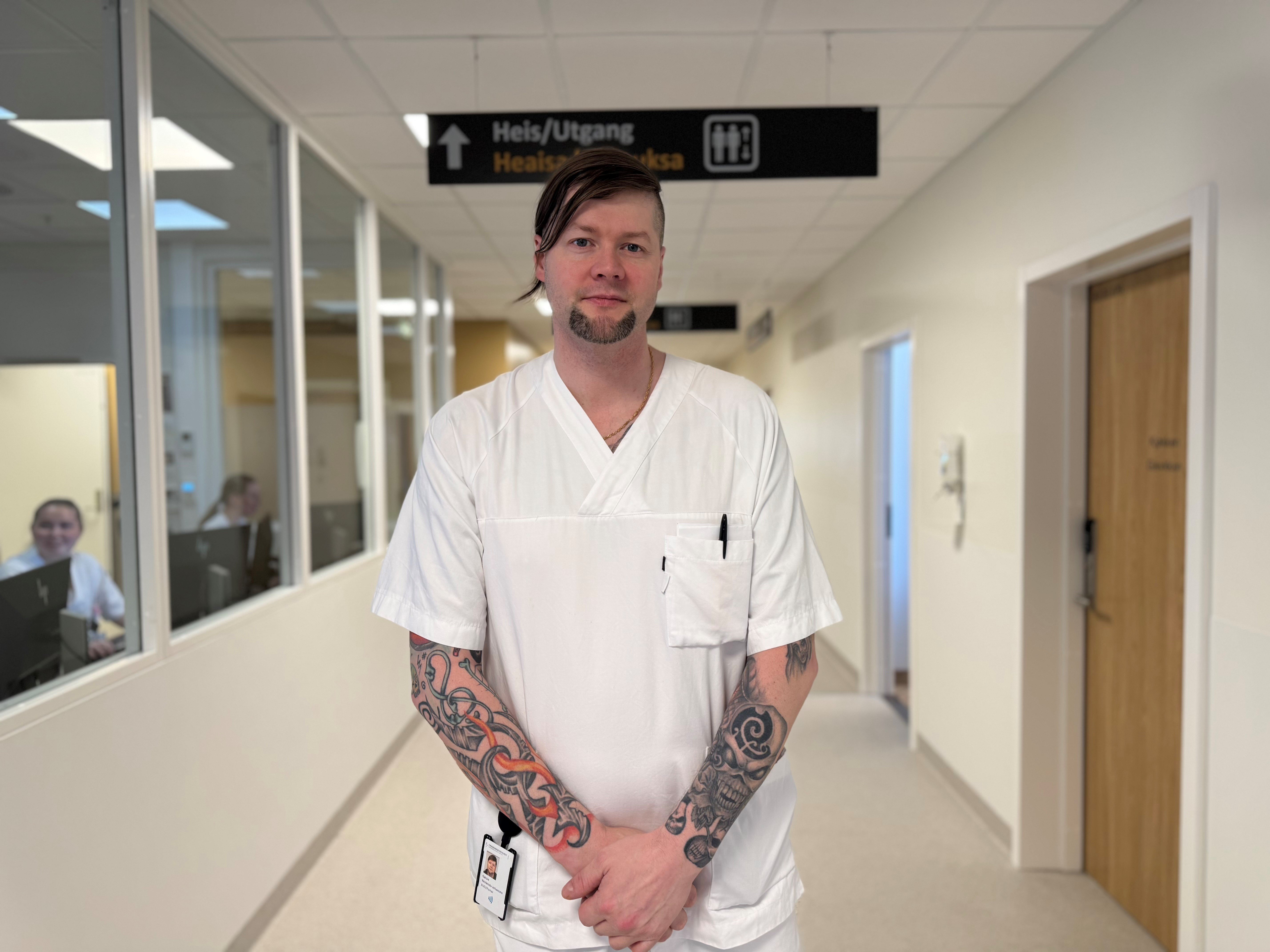 En mann med tatoveringer i en korridor