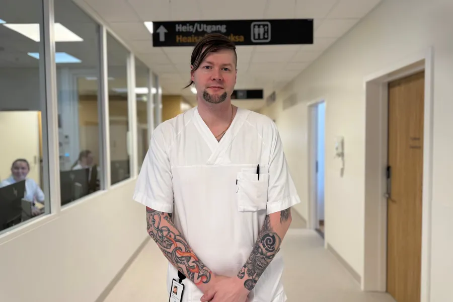 En mann med tatoveringer i en korridor