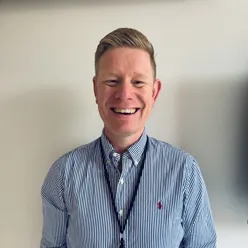 En mann som smiler til kameraet