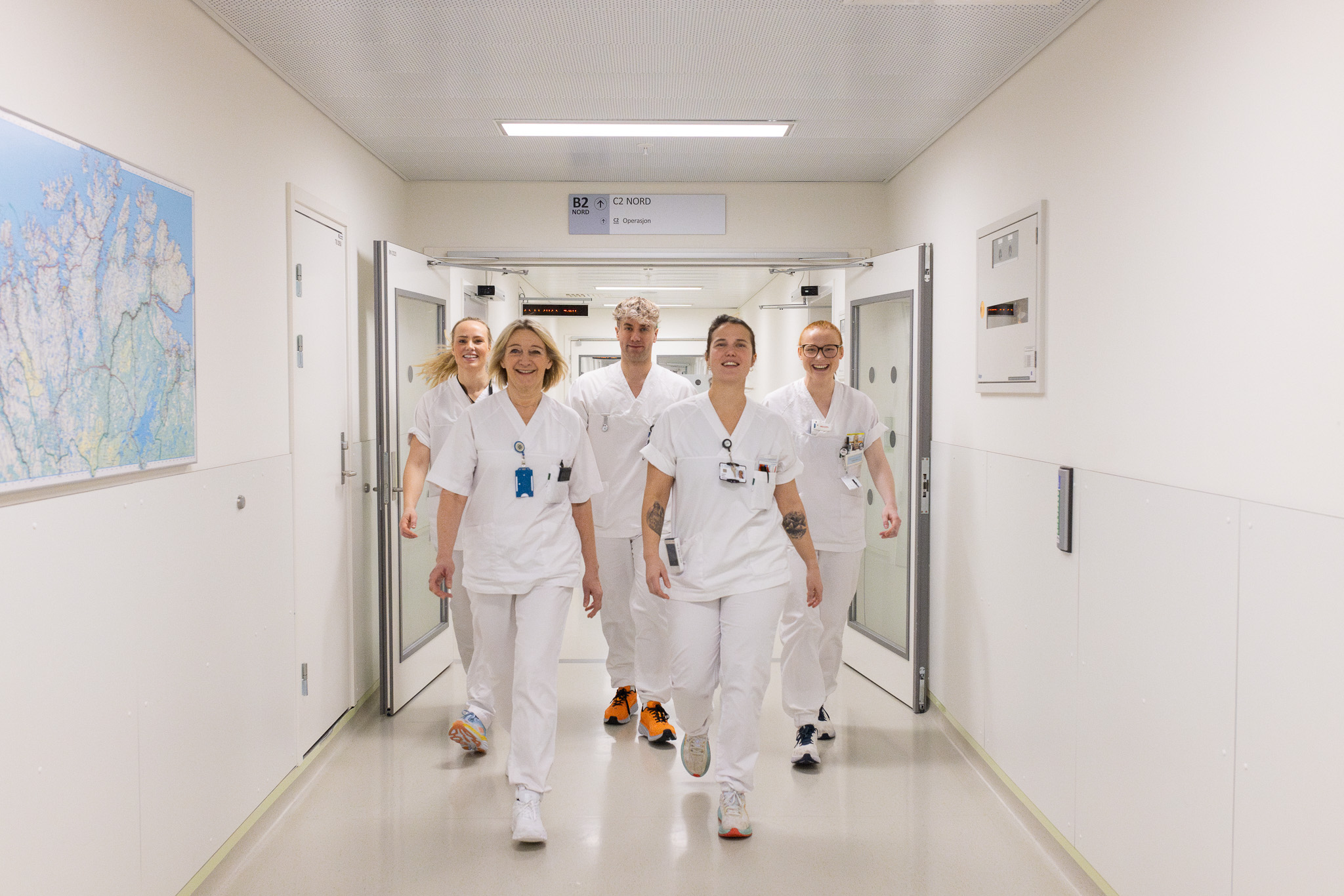 En grupp eansatte i hvite uniformerer som går gjennom sykehuset