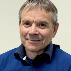 En mann som smiler til kameraet