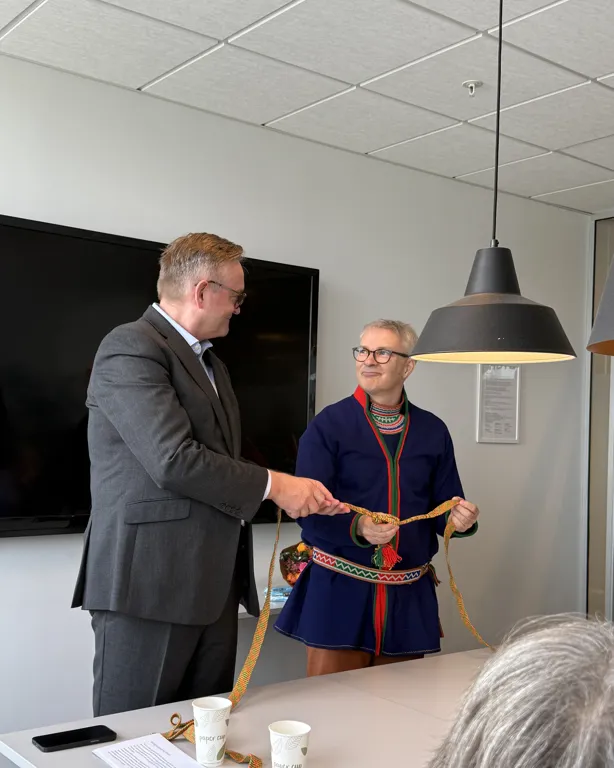 En person som gir en annen mann en medalje