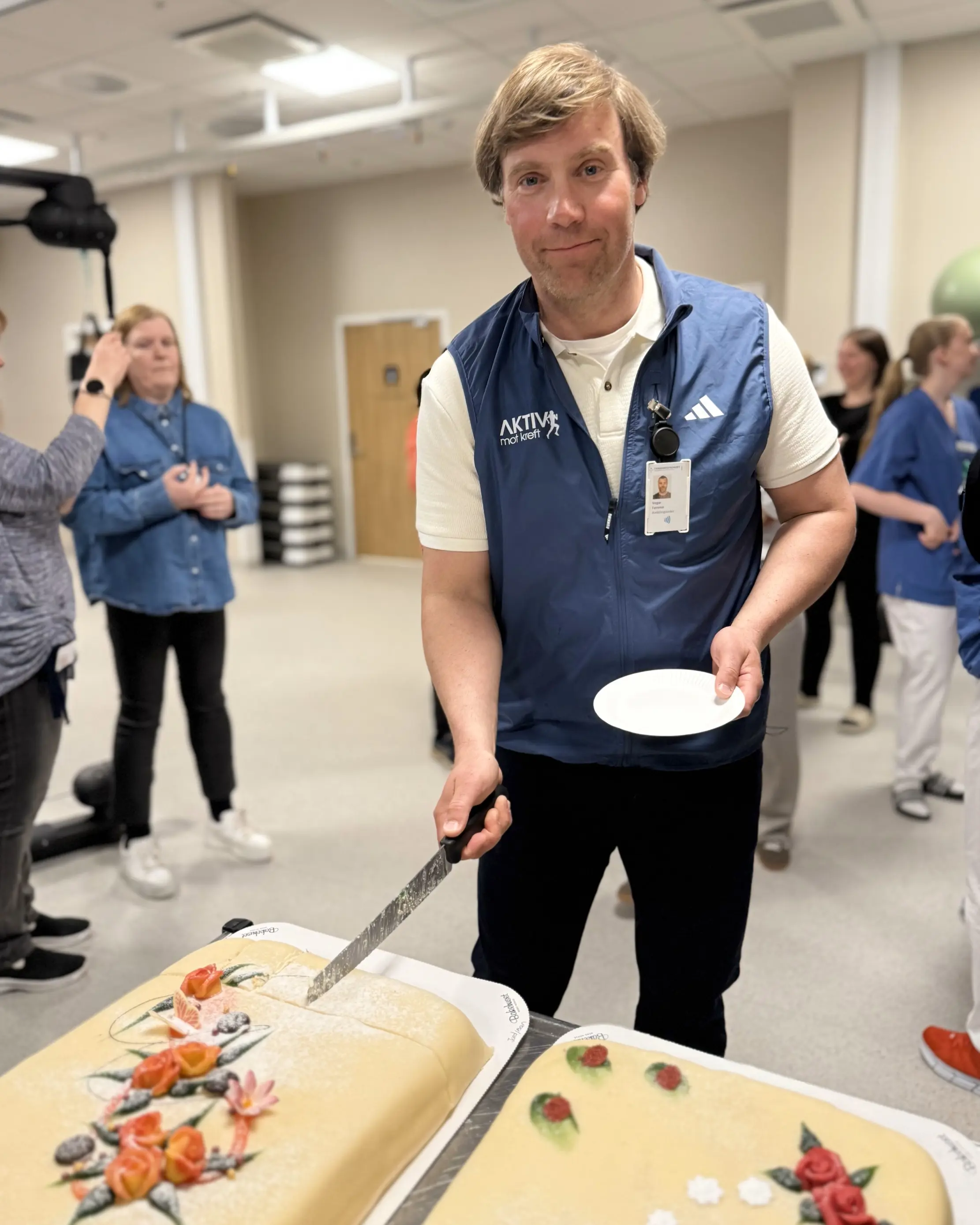En person som holder en kniv og skjærer en kake