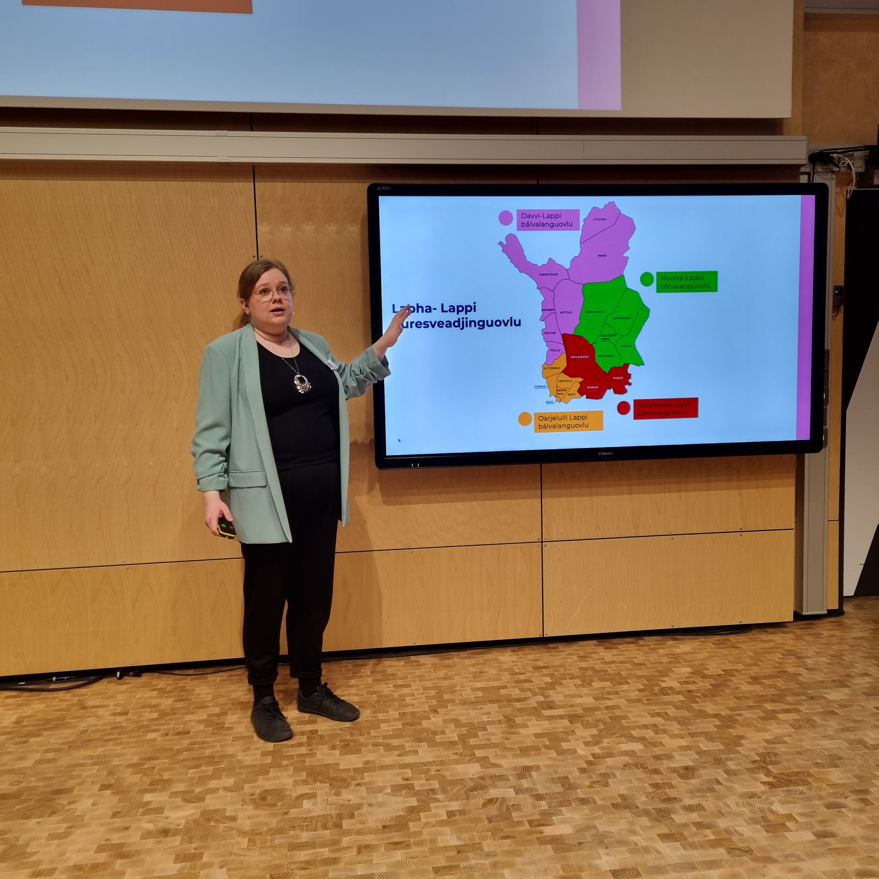 En person som står foran en stor skjerm