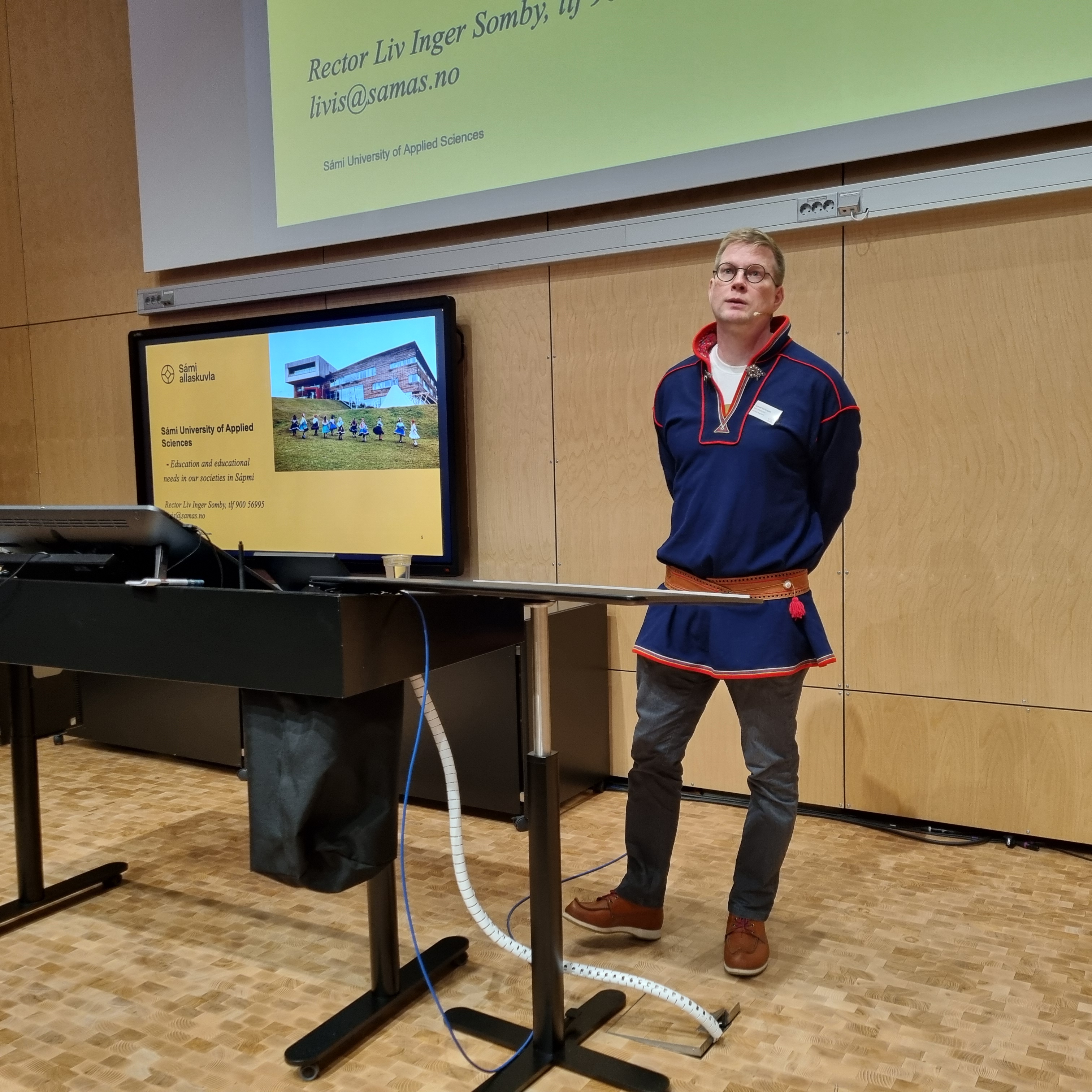 En mann som står ved siden av et podium