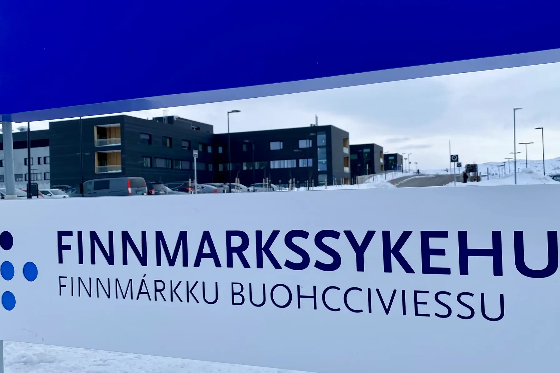 Bilde av Kirkenes sykehus, med skiltet i forgrunnen.