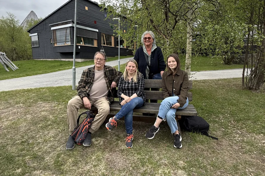 En gruppe mennesker som sitter på en benk i en park