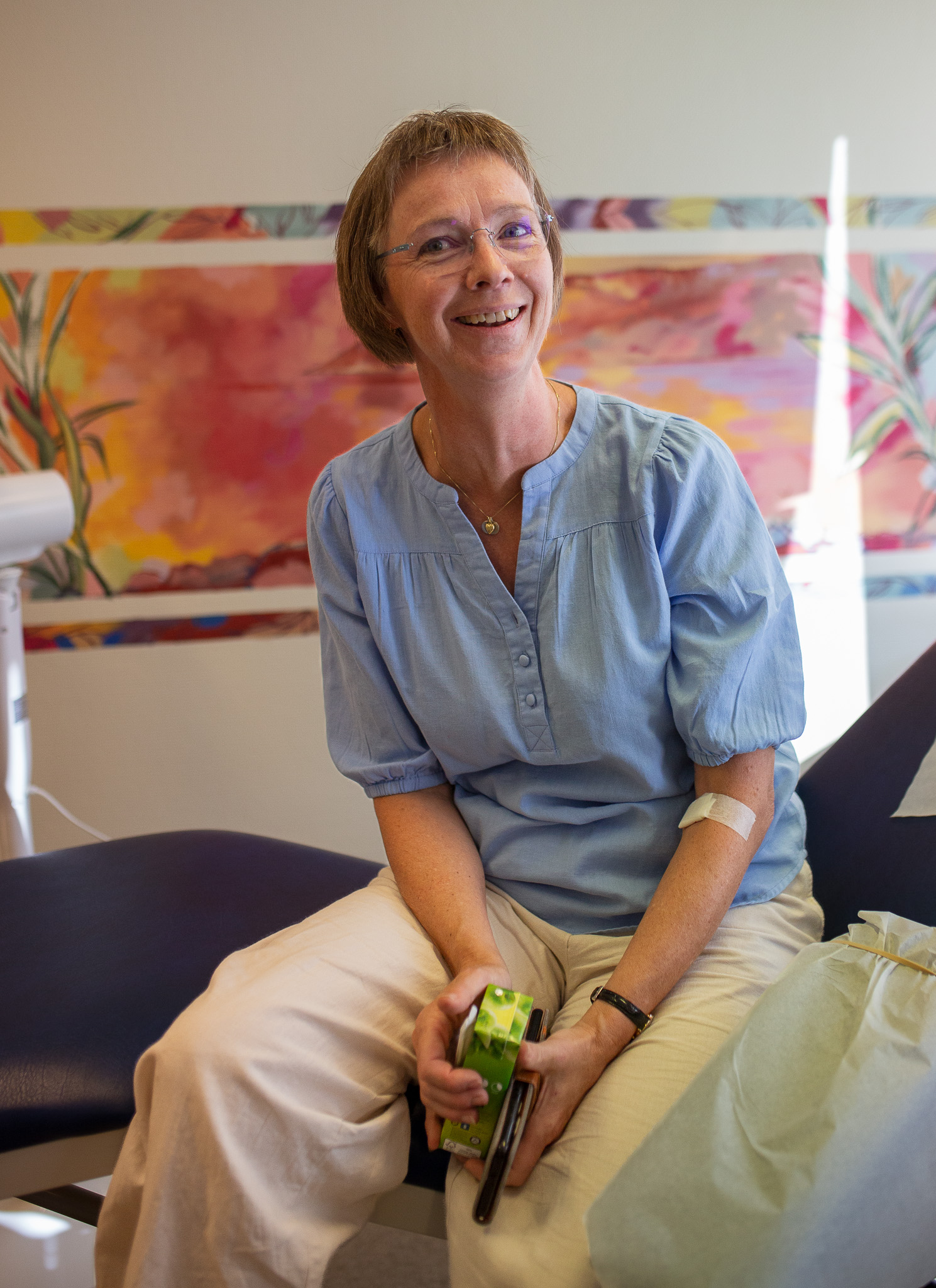 En mann som sitter på en sofa og holder en grønn flaske