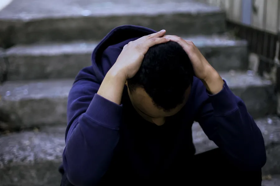 En person som dekker ansiktet med hendene