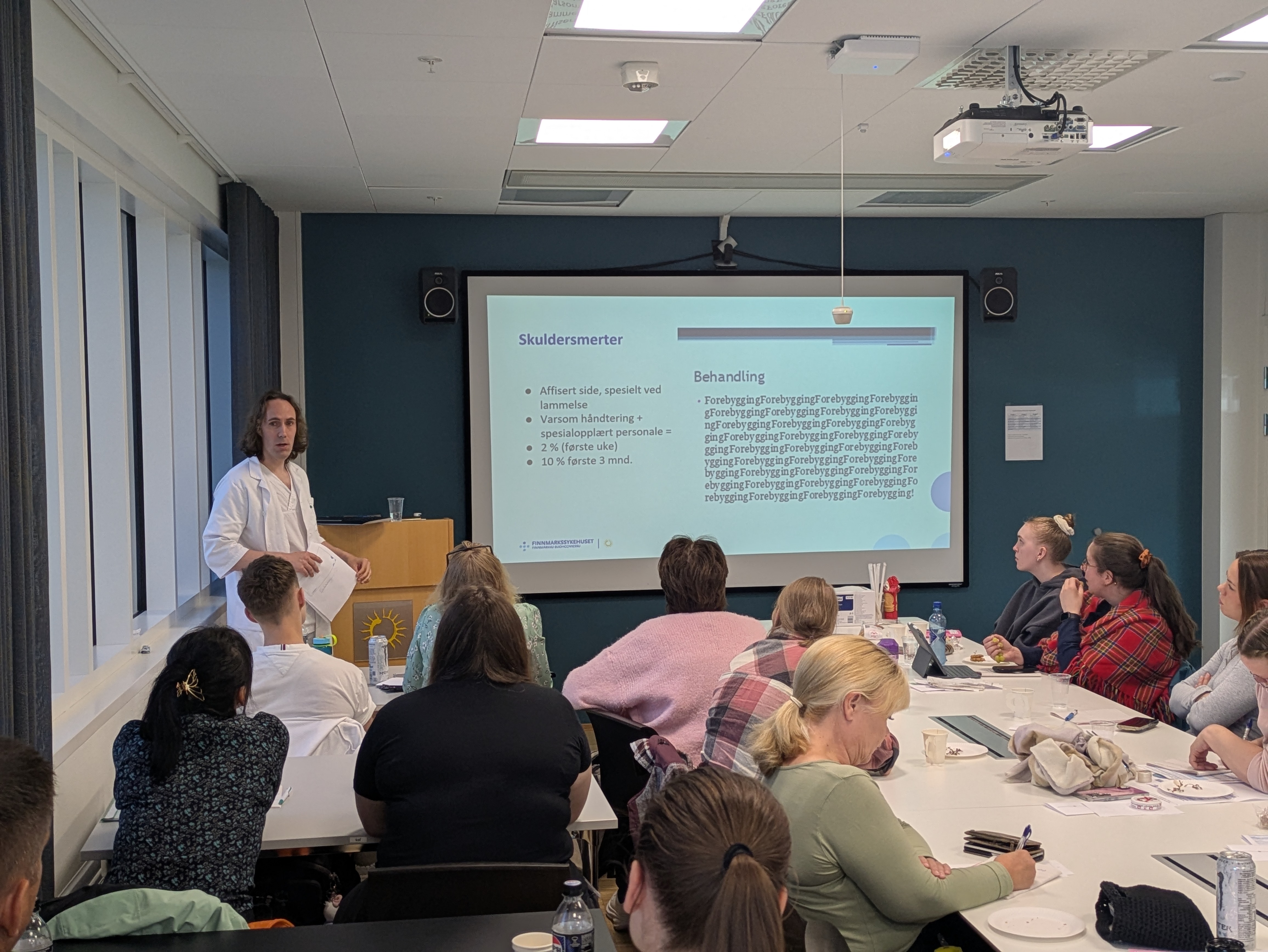 En person som holder en presentasjon for en gruppe mennesker