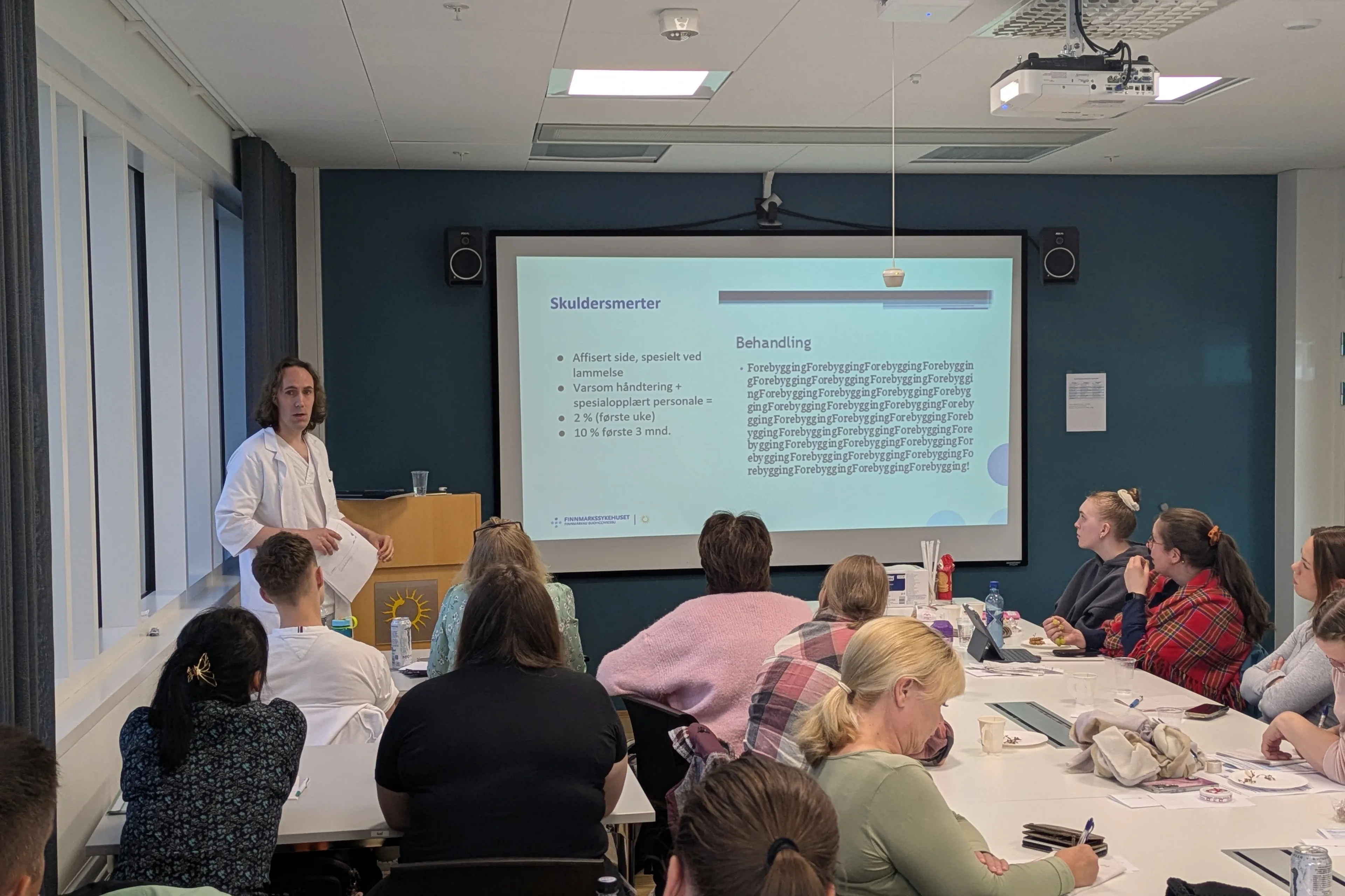 En person som holder en presentasjon for en gruppe mennesker