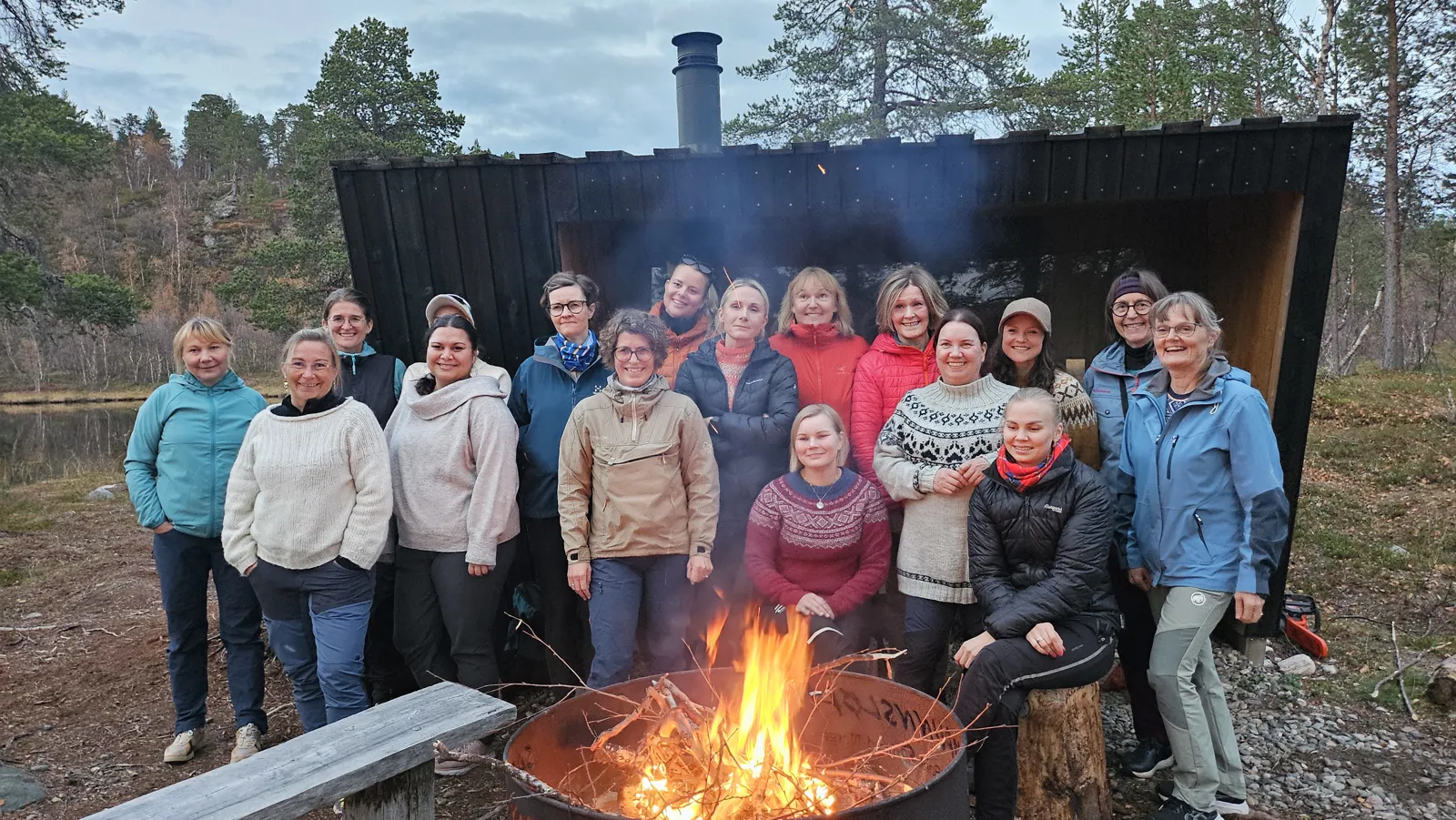 En gruppe mennesker som poserer for et bilde ved siden av et bål