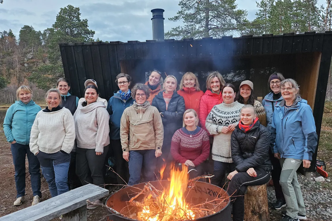 En gruppe mennesker som poserer for et bilde ved siden av et bål