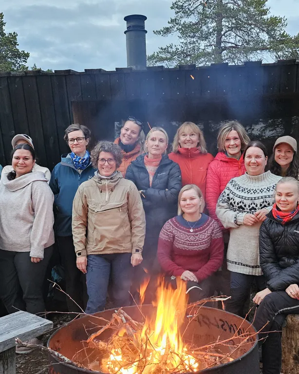 En gruppe mennesker som poserer for et bilde ved siden av et bål