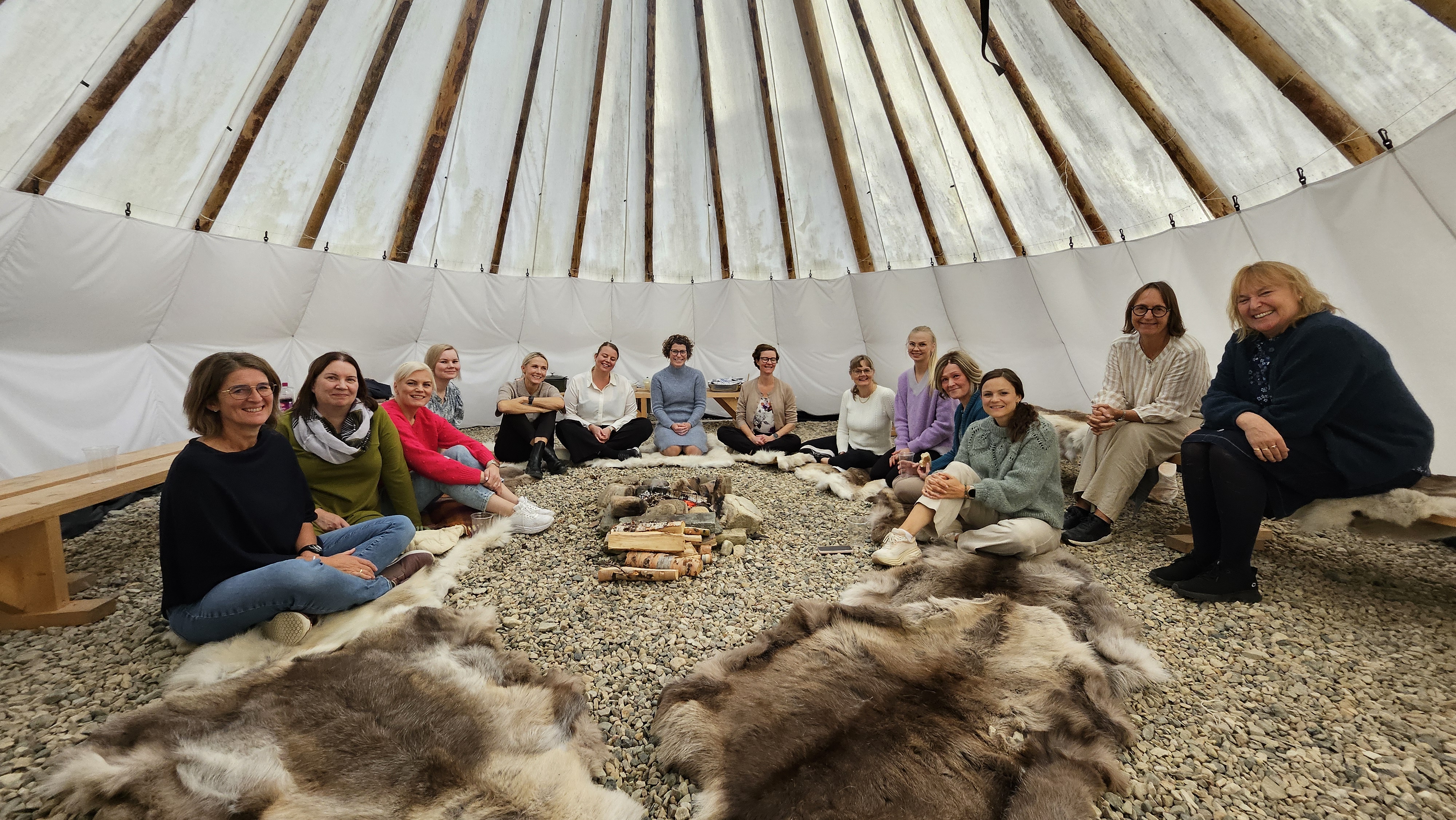 En gruppe mennesker som sitter på en haug med høy