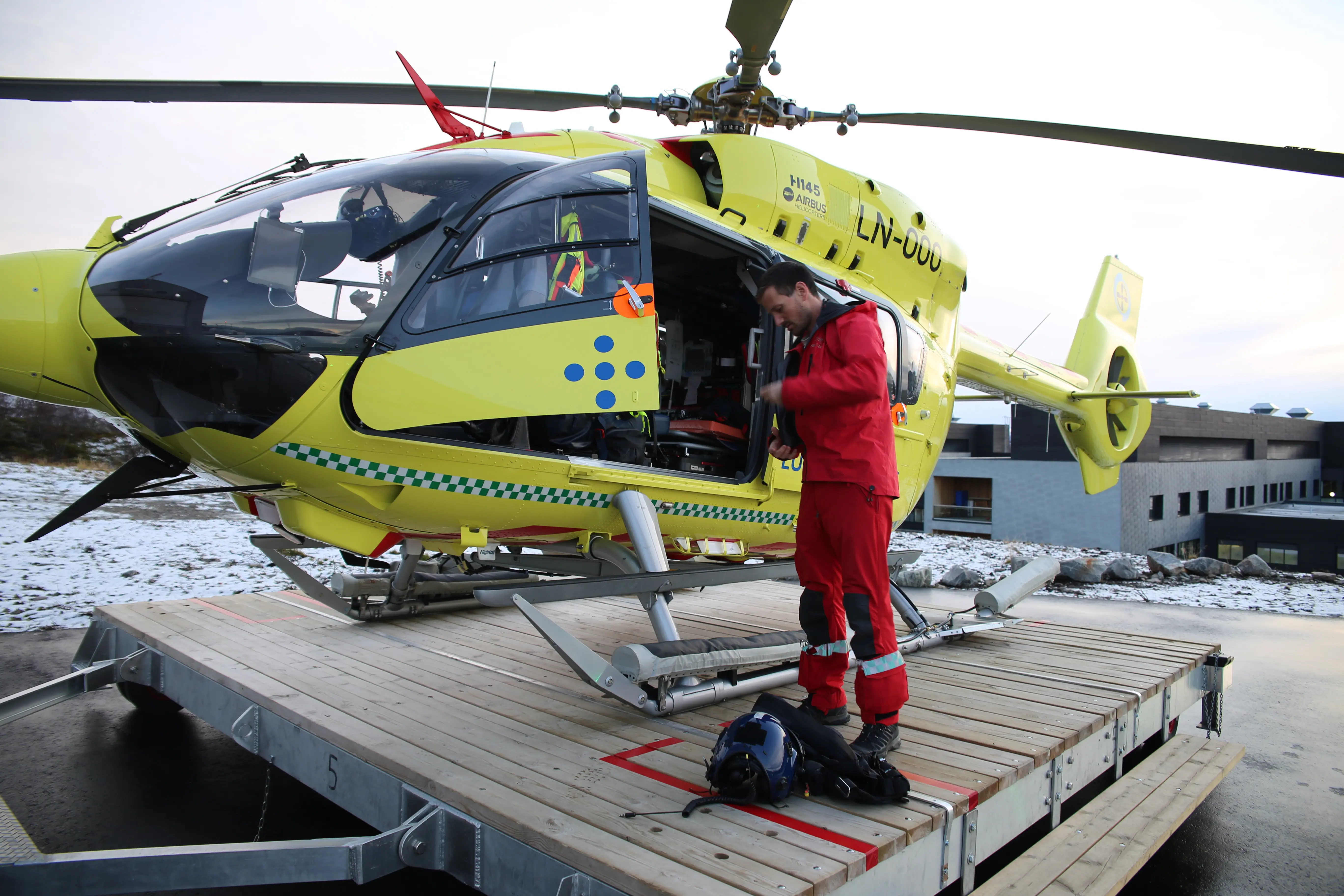 Redningsmann Håkon Larssen gjør helikopteret klart på utesiden av hagaren.