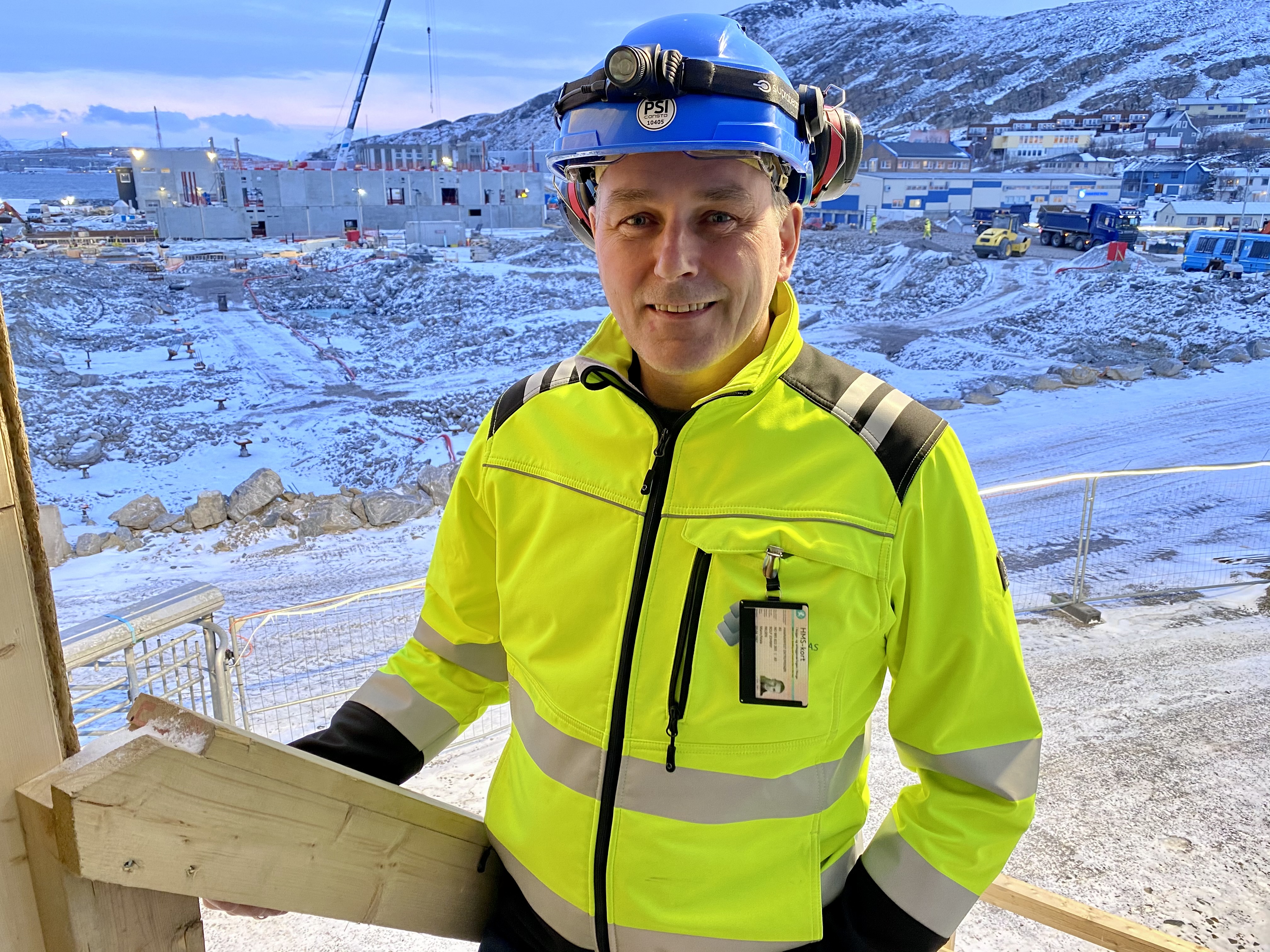 Portrettbilde av Rolf Johnny Olsen med byggeplassen i bakgrunnen.