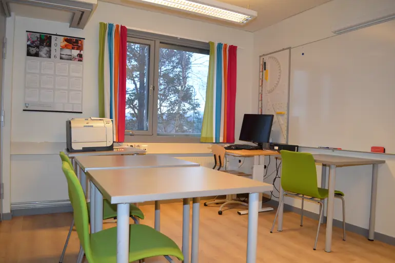 Et rom med skrivebord og stoler