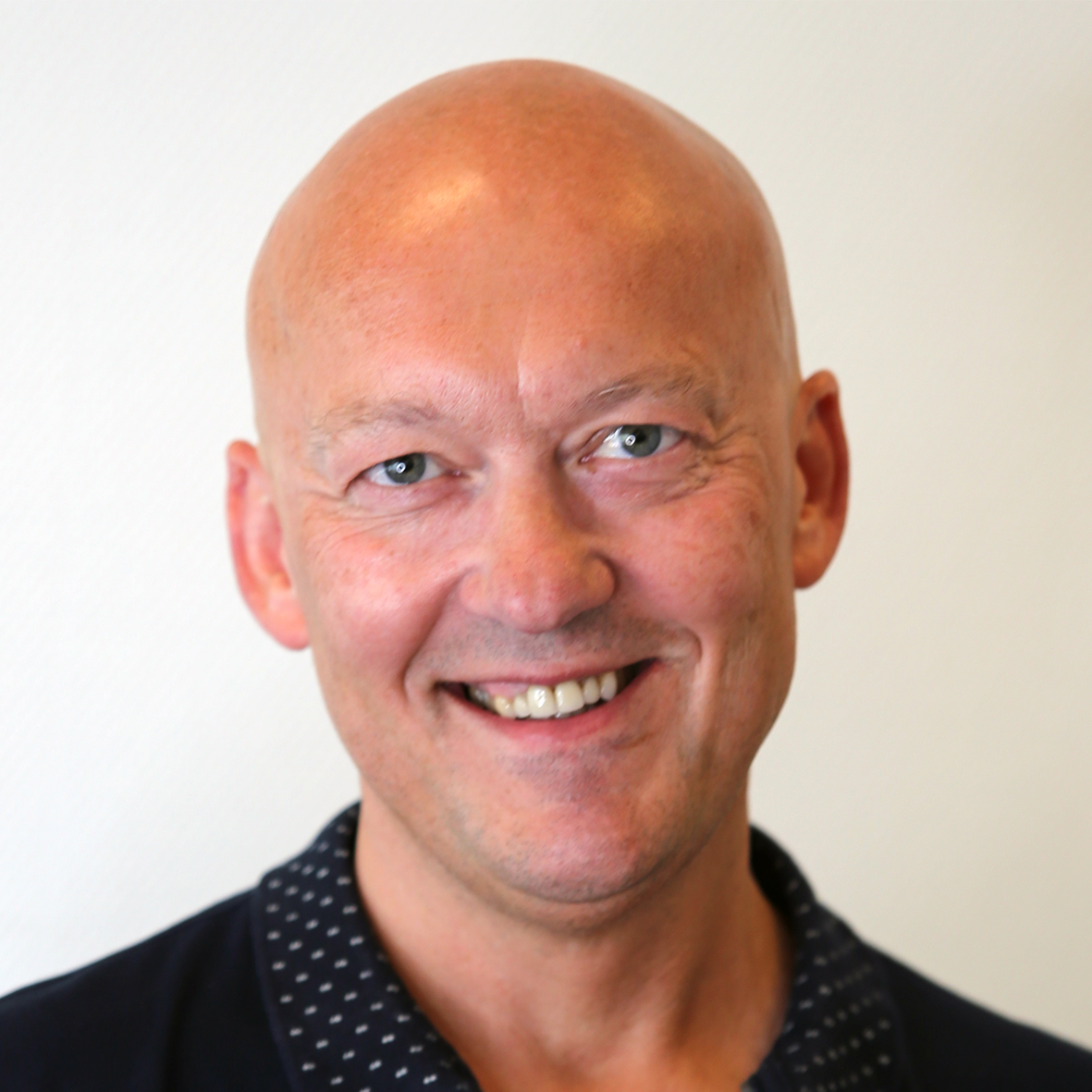 En skallet mann smiler