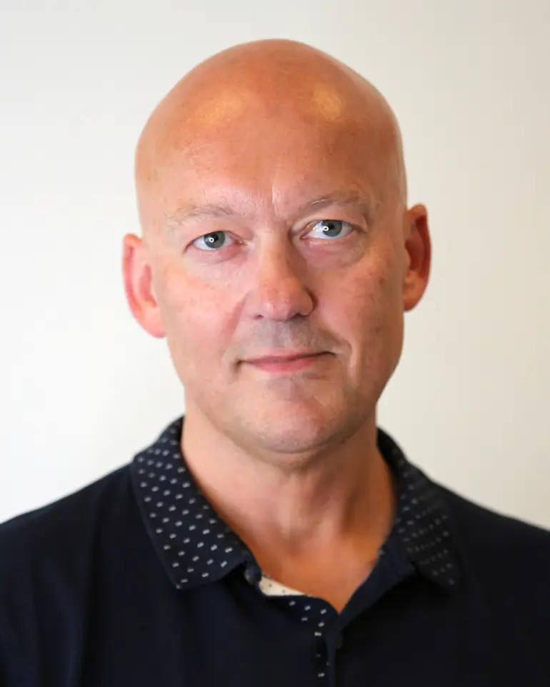 En skallet mann i svart skjorte