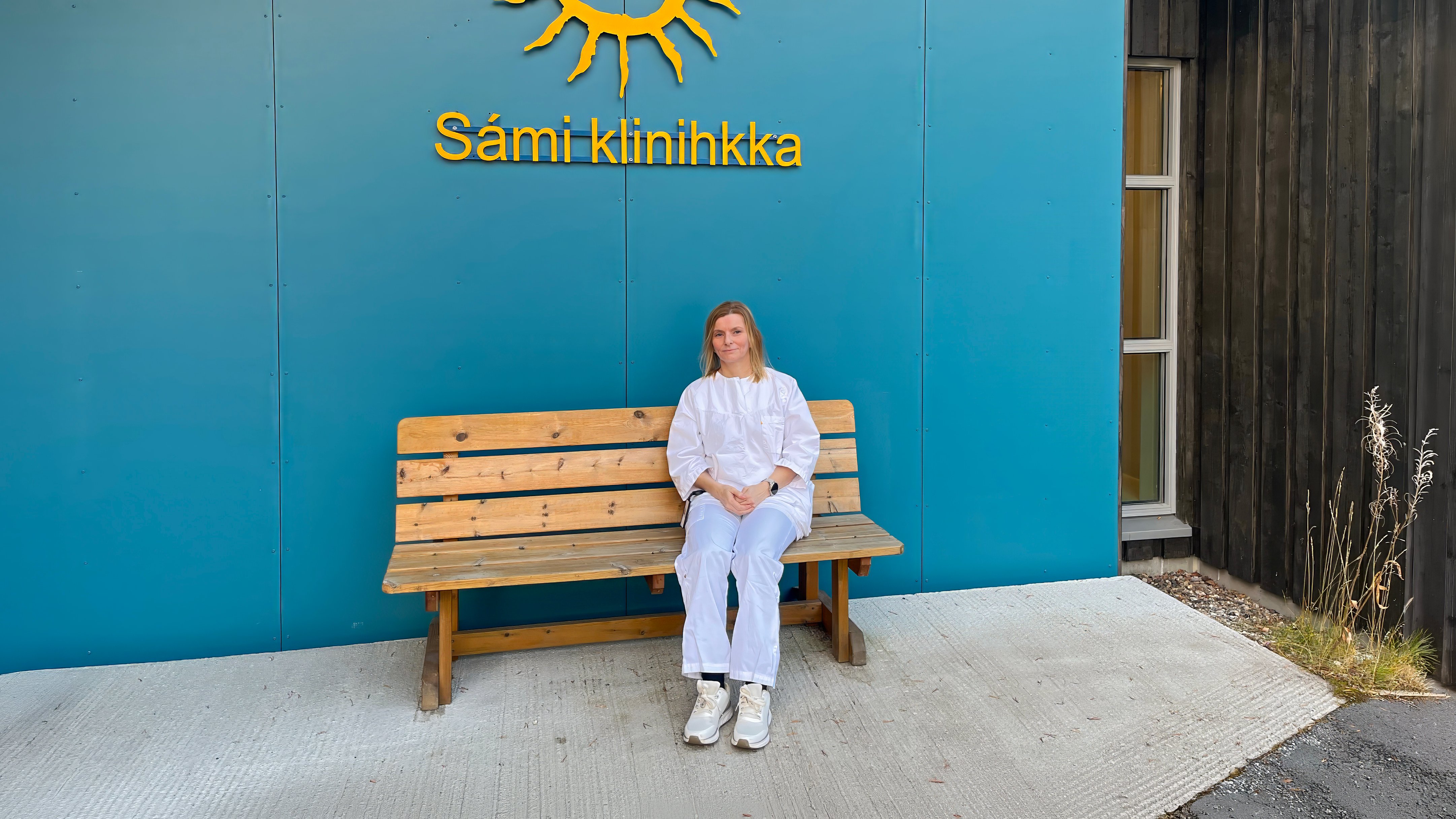 Nordsamisk tolk sitter på en benk utenfor Sámi klinihkka.