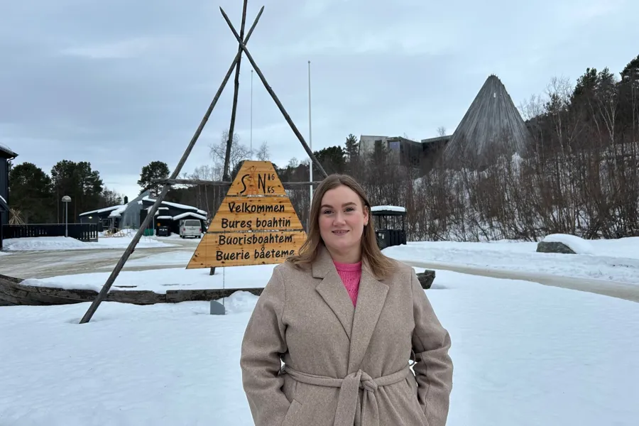 En person som står i snøen ved siden av et skilt