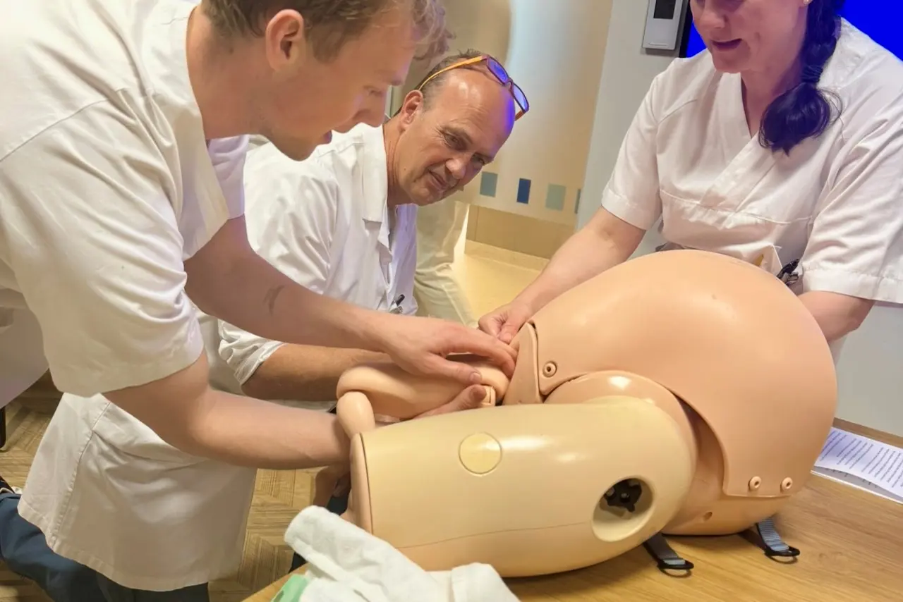 En gruppe mennesker i hvite laboratoriefrakker som jobber med et stykke papir