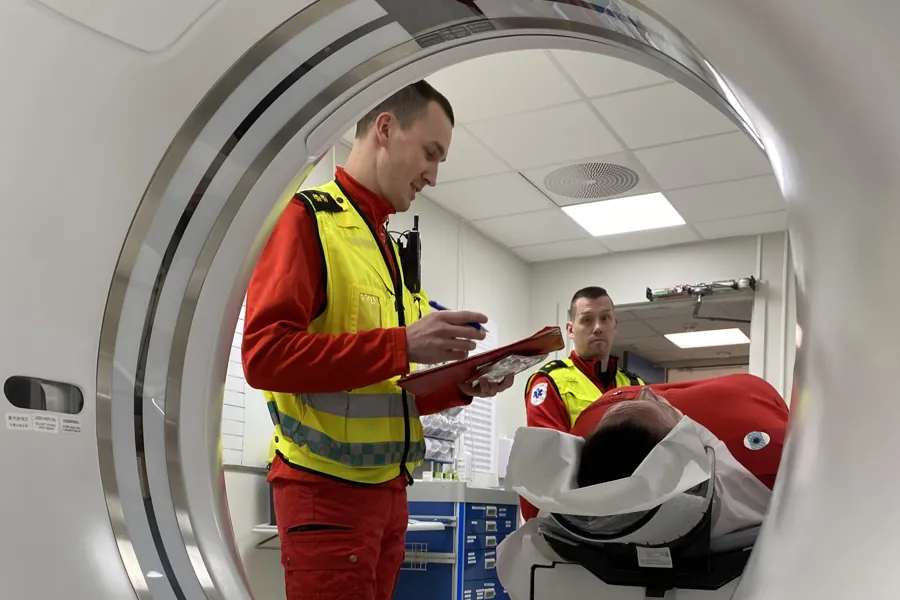 En mann i oransje vest som ser på en mann i sikkerhetsvest