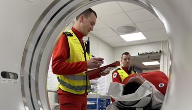 En mann i oransje vest som ser på en mann i sikkerhetsvest