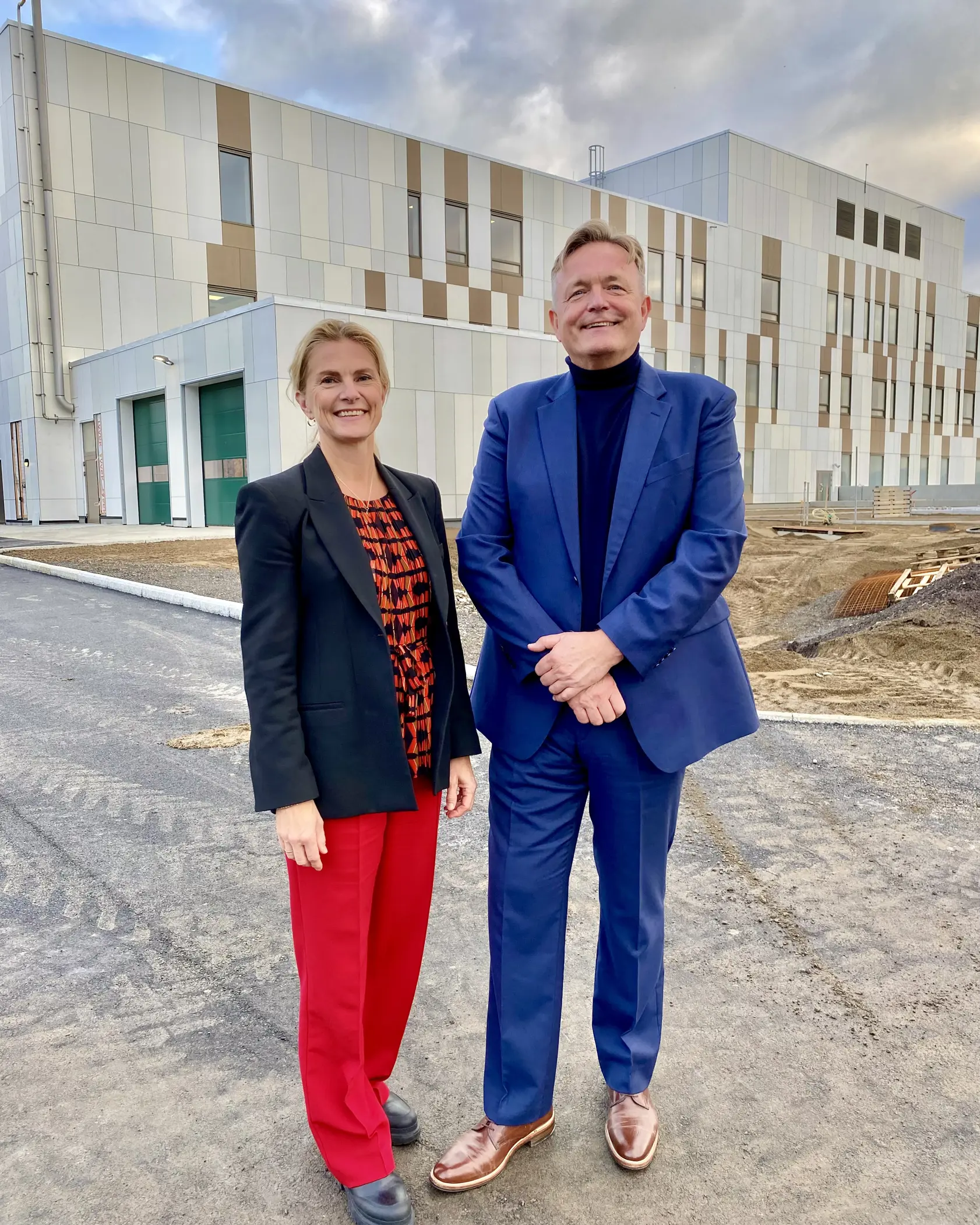 En mann og en kvinne som står foran en bygning